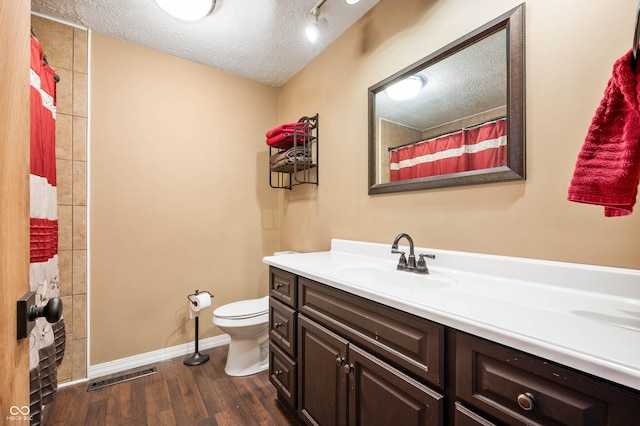 bathroom featuring toilet, wood-type flooring, a textured ceiling, vanity, and a shower with shower curtain