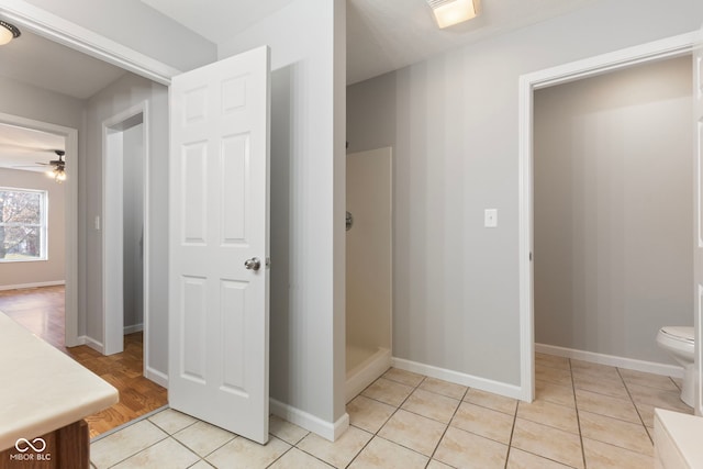 bathroom featuring vanity, tile patterned flooring, ceiling fan, toilet, and walk in shower