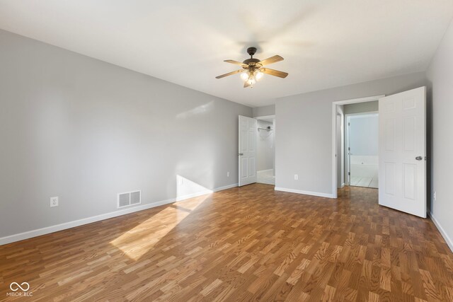 unfurnished bedroom with ceiling fan and dark wood-type flooring