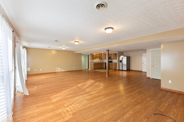 2395 W Robin Rd, Scottsburg, IN 47170 - unfurnished living room featuring light wood-type flooring and a textured ceiling