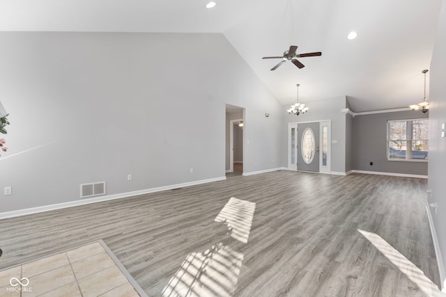 unfurnished living room featuring high vaulted ceiling, light hardwood / wood-style floors, and ceiling fan with notable chandelier