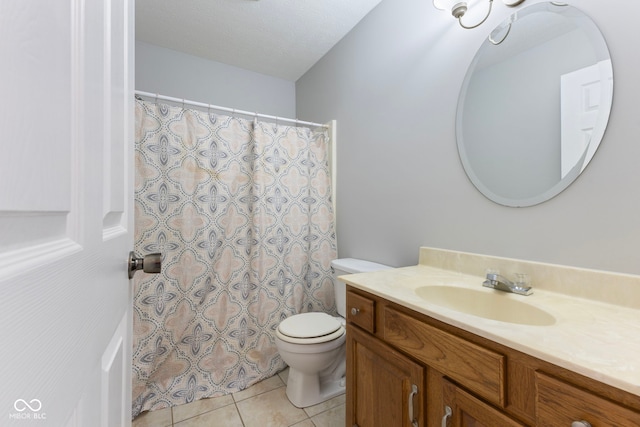 bathroom featuring tile patterned flooring, vanity, a textured ceiling, and toilet