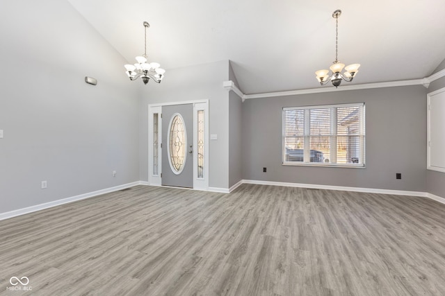 entryway featuring ornamental molding, light wood-type flooring, and an inviting chandelier