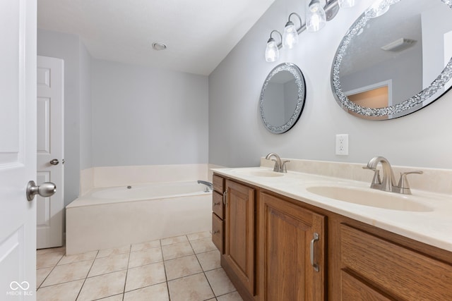 bathroom featuring tile patterned flooring, a bath, and vanity