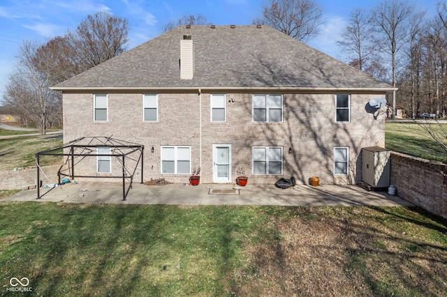 back of house featuring a lawn, a storage unit, and a patio area