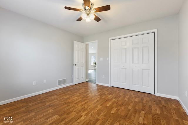 unfurnished bedroom with wood-type flooring, a closet, and ceiling fan