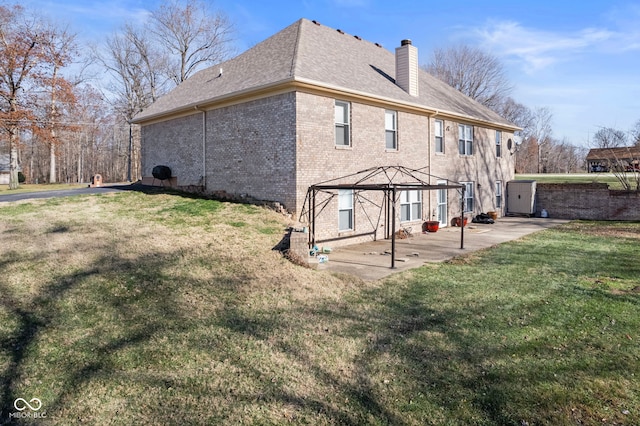 rear view of house with a gazebo, a patio, and a lawn