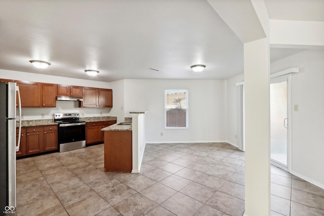 kitchen with light stone countertops, sink, light tile patterned flooring, and appliances with stainless steel finishes