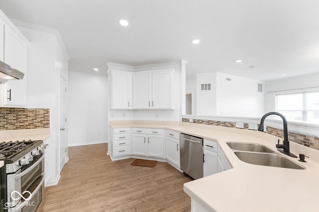 kitchen with white cabinets, backsplash, stainless steel appliances, and sink