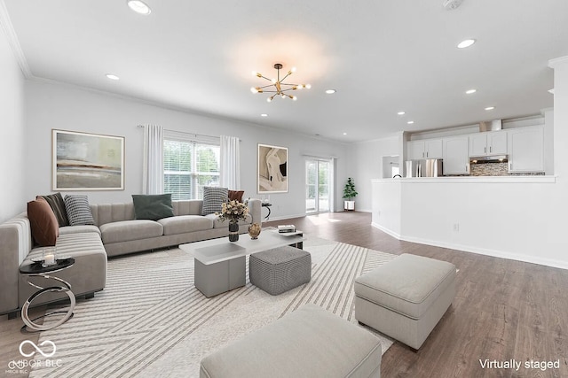 living room featuring light hardwood / wood-style floors, crown molding, and an inviting chandelier