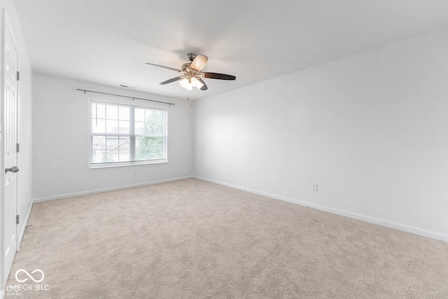 carpeted spare room featuring ceiling fan