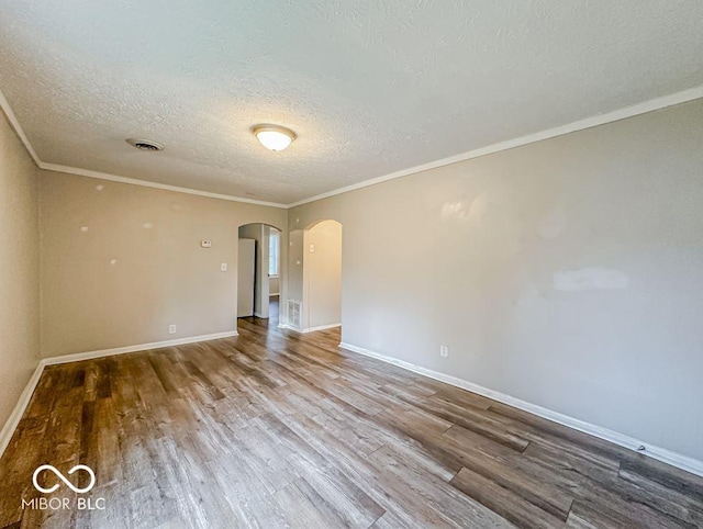 spare room with a textured ceiling, hardwood / wood-style flooring, and crown molding