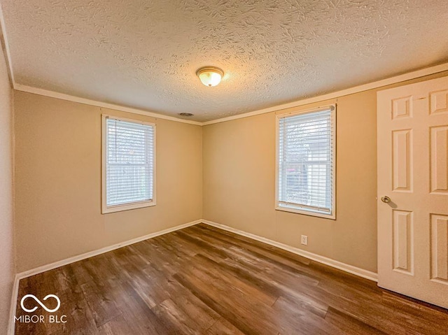 unfurnished room featuring dark wood-type flooring, a textured ceiling, and ornamental molding