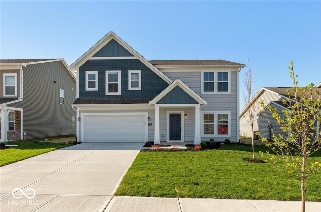 traditional home featuring a garage, a front yard, and driveway