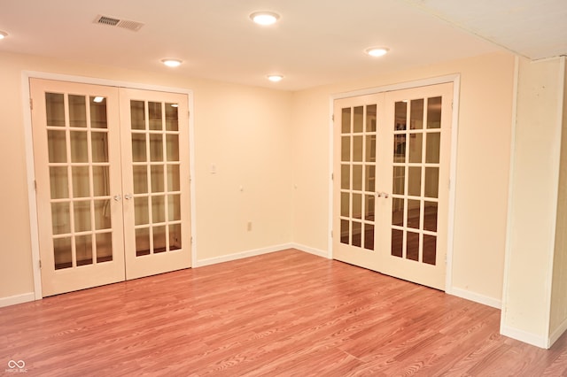 unfurnished room featuring french doors and light hardwood / wood-style flooring