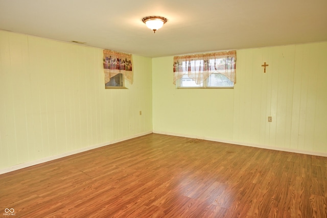 unfurnished room with wood walls and wood-type flooring