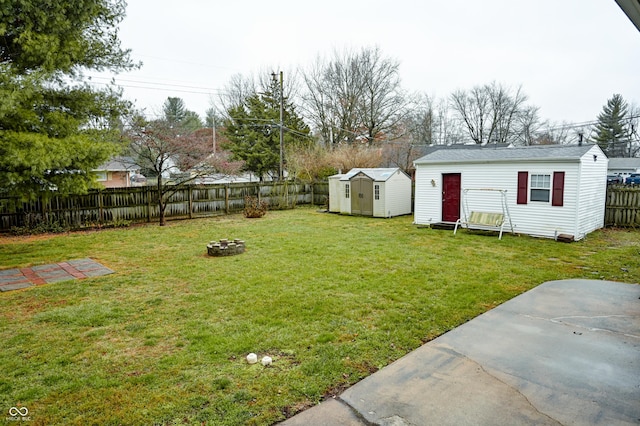 view of yard featuring an outdoor fire pit, a patio area, and a storage unit