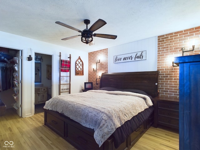 bedroom featuring a spacious closet, ceiling fan, light wood-type flooring, and a closet