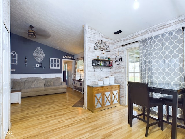 dining room with ceiling fan, light hardwood / wood-style flooring, and lofted ceiling