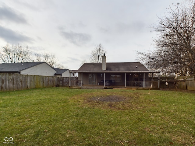 rear view of house with a deck and a lawn