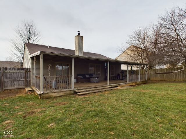 back of property with a lawn and a wooden deck