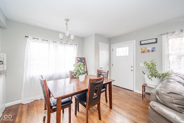 dining room with wood-type flooring and an inviting chandelier