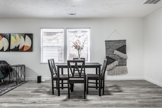 dining room featuring hardwood / wood-style floors and a textured ceiling