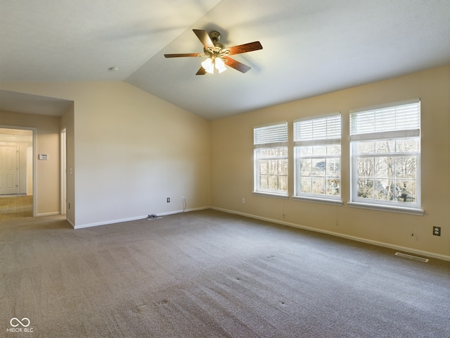 carpeted spare room with vaulted ceiling and ceiling fan