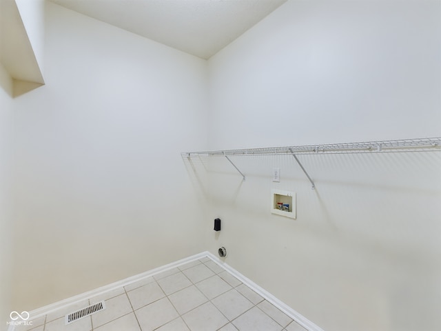 washroom with hookup for a washing machine and light tile patterned floors