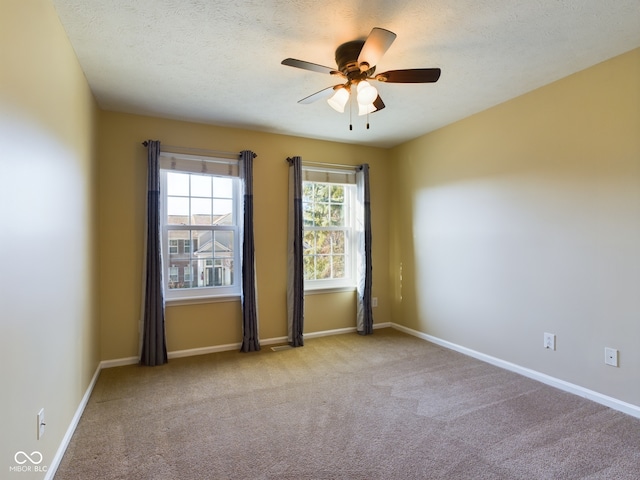 carpeted spare room featuring ceiling fan and a textured ceiling