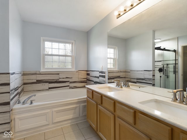 bathroom featuring tile patterned flooring, vanity, tile walls, and shower with separate bathtub