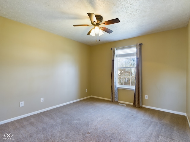 spare room featuring carpet flooring, ceiling fan, and a textured ceiling