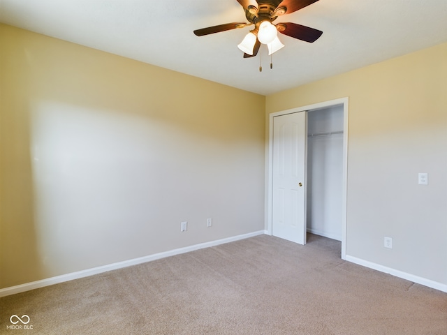 unfurnished bedroom featuring ceiling fan, light carpet, and a closet