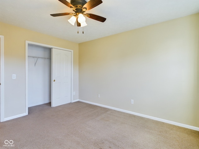 unfurnished bedroom with ceiling fan, a closet, and light colored carpet