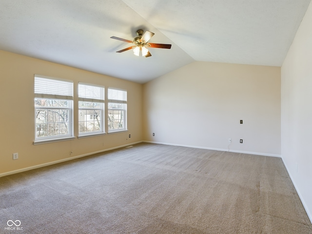 carpeted spare room with vaulted ceiling and ceiling fan