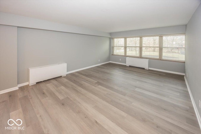 spare room featuring light wood-type flooring and radiator heating unit