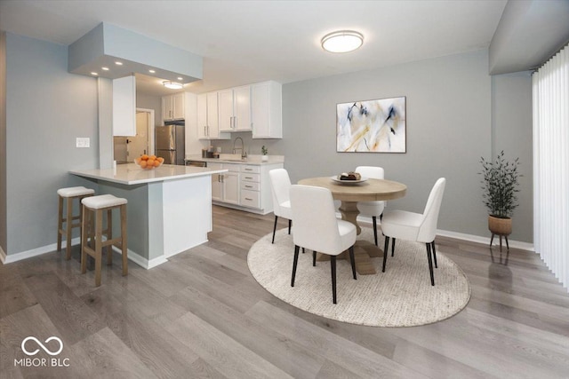 dining space featuring light wood-type flooring and sink