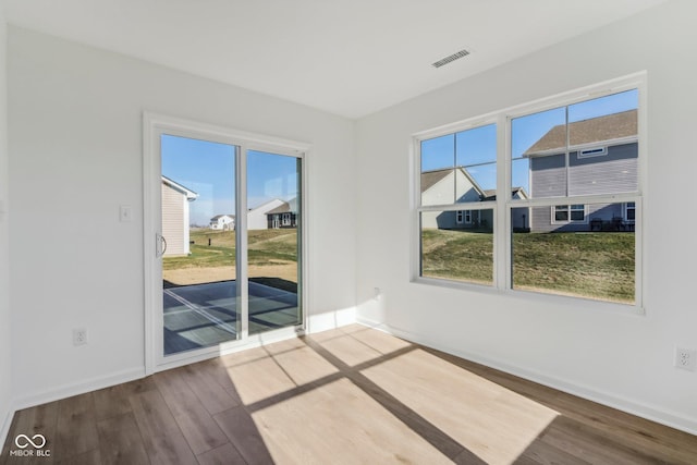 unfurnished room featuring hardwood / wood-style flooring and a wealth of natural light