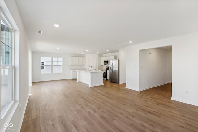 unfurnished living room featuring light hardwood / wood-style floors and sink