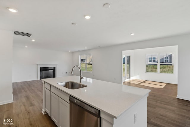 kitchen with dark hardwood / wood-style flooring, white cabinets, sink, a center island with sink, and dishwasher