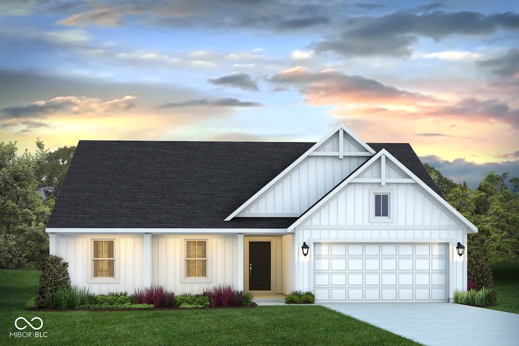 modern farmhouse style home featuring a lawn and a garage