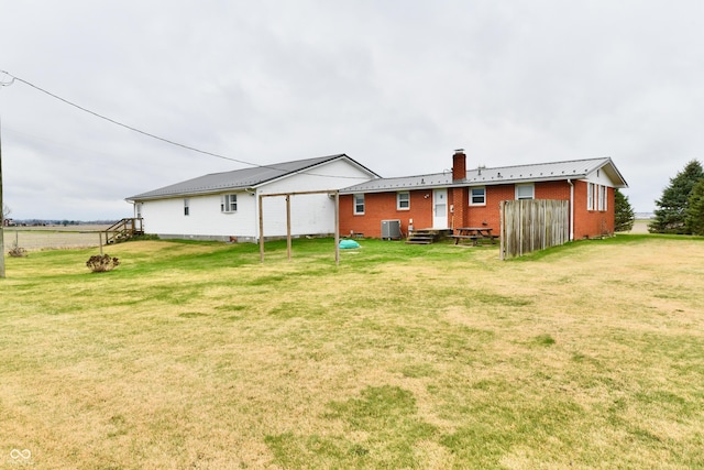 back of property featuring a lawn and central AC unit