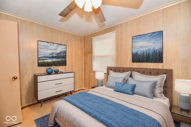 carpeted bedroom featuring ceiling fan and wooden walls