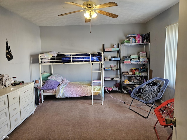 carpeted bedroom featuring ceiling fan and a textured ceiling