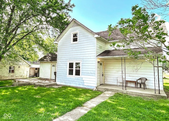 rear view of property featuring a lawn and a patio