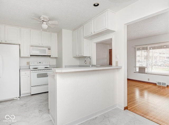 kitchen featuring kitchen peninsula, a textured ceiling, white appliances, and white cabinets