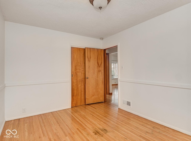 spare room with hardwood / wood-style floors and a textured ceiling