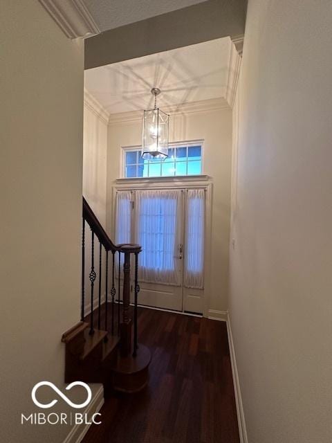 entrance foyer with a notable chandelier, dark hardwood / wood-style flooring, and ornamental molding