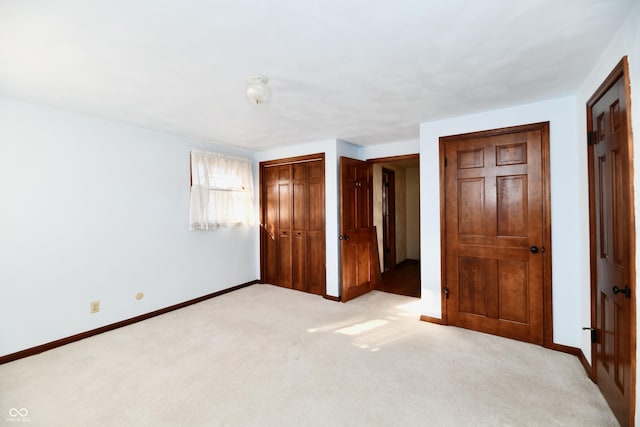 unfurnished bedroom with light carpet and two closets