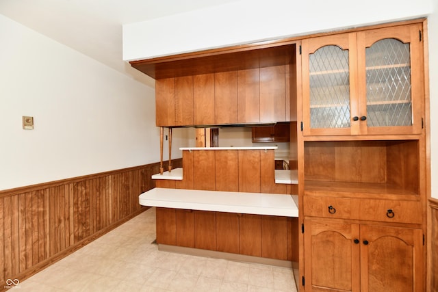 kitchen featuring kitchen peninsula and wooden walls